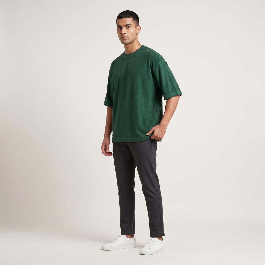 Model wearing Bottle Green oversized t-shirt, front three-quarter view