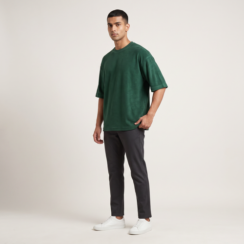 Model wearing Bottle Green oversized t-shirt, front three-quarter view