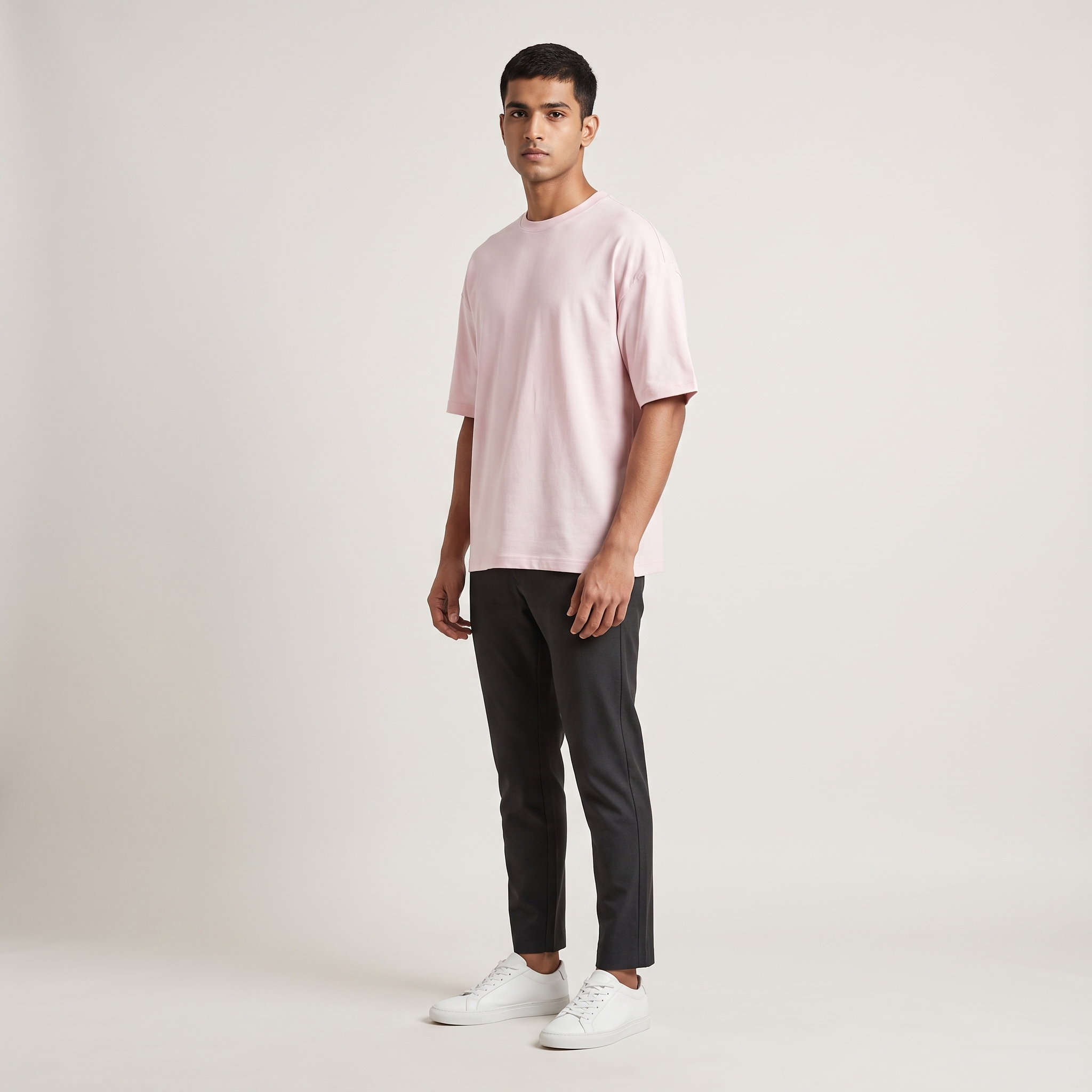 Model wearing Classic Baby Pink oversized t-shirt, front three-quarter view