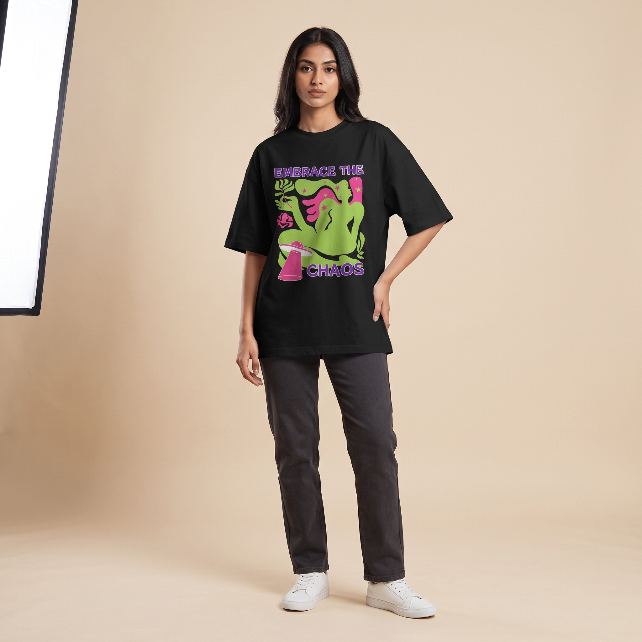 Female model wearing Embrace The Chaos oversized t-shirt, front view showing chest print