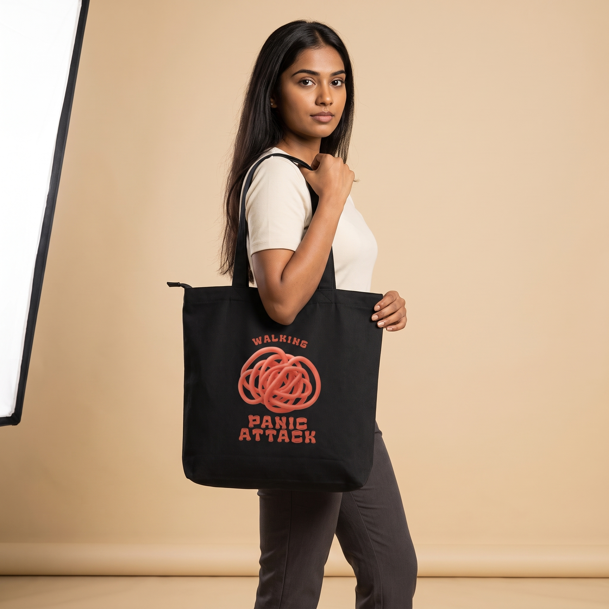 Model carrying Walking Panic Attack zippered large tote bag in black canvas, front print visible